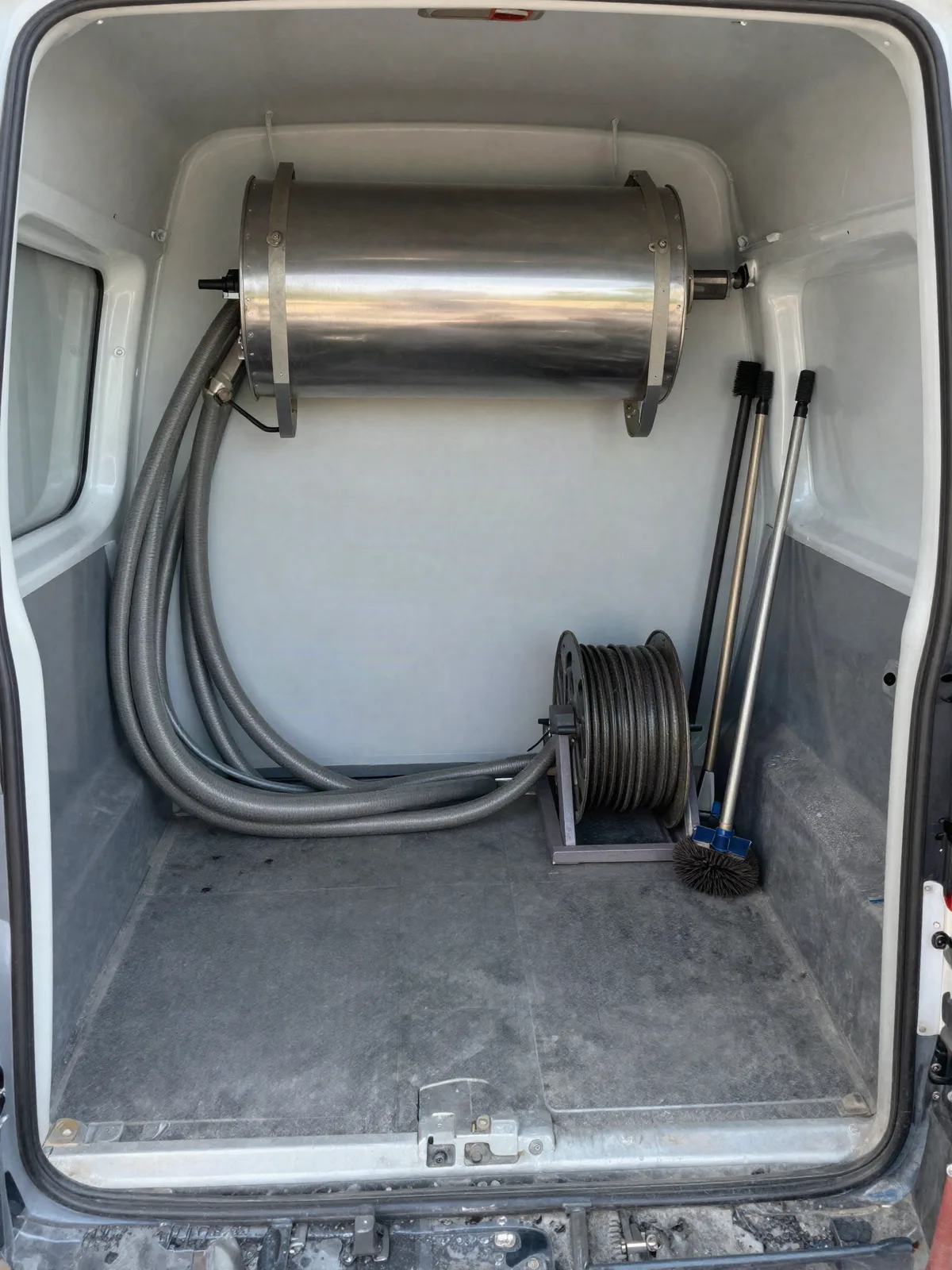 Duct cleaning collection equipment and hoses staged on a driveway
