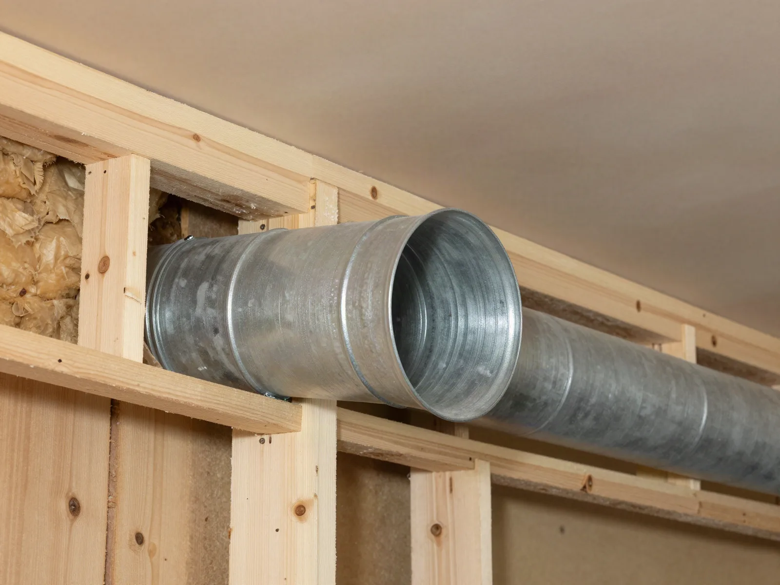 Dryer vent line running through a wall cavity from the laundry room to the exterior hood